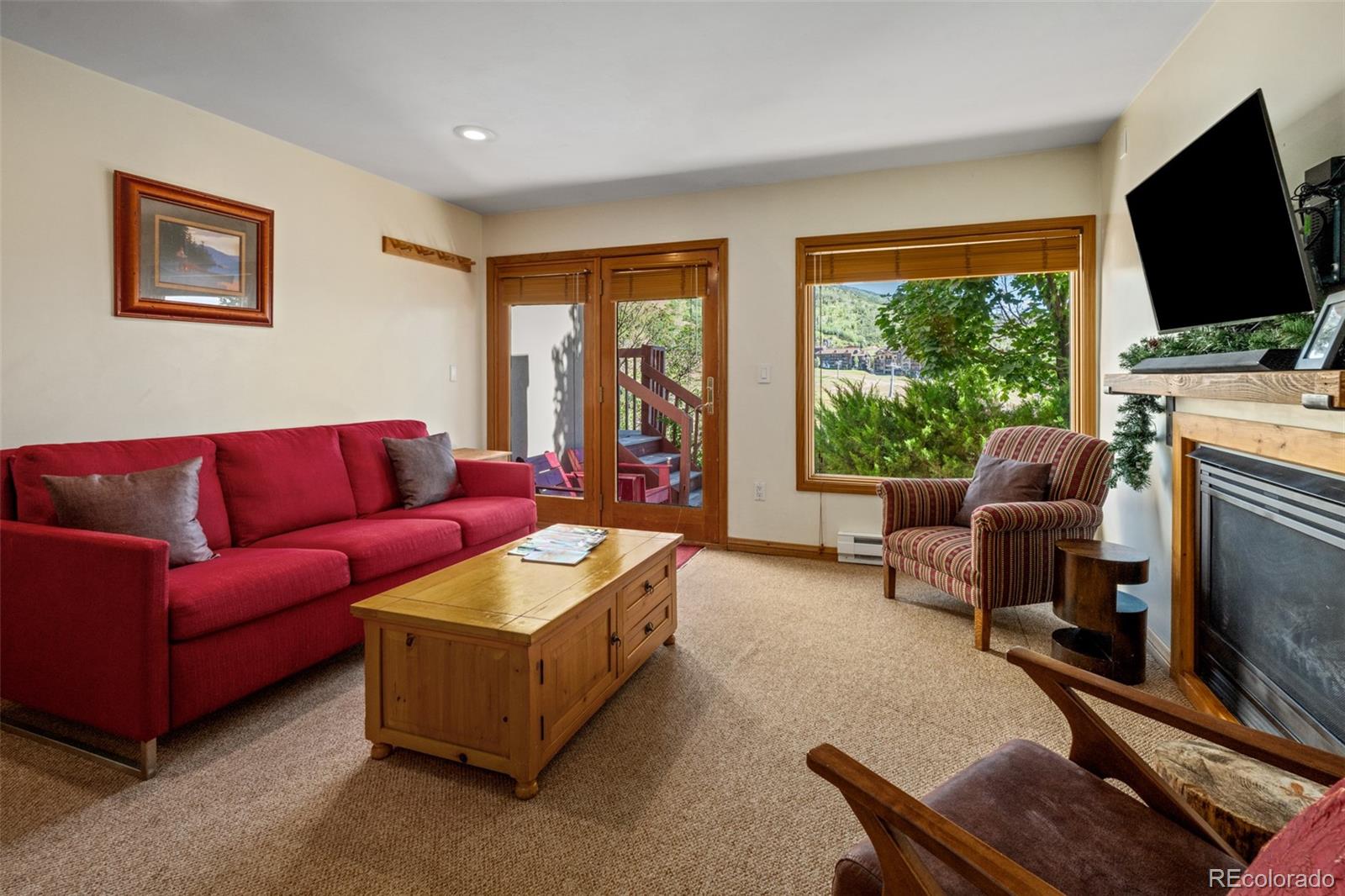 1800 Burgess Creek Road, Unit 205 Steamboat Springs, CO 80487 - Photo 3 of 28 a living room with fireplace furniture and a flat screen tv