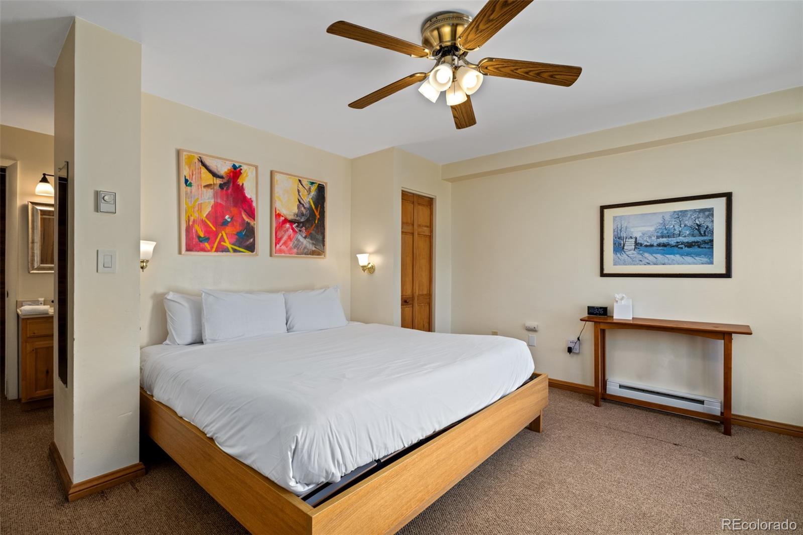 1800 Burgess Creek Road, Unit 205 Steamboat Springs, CO 80487 - Photo 6 of 28 a bedroom with a bed and a chandelier