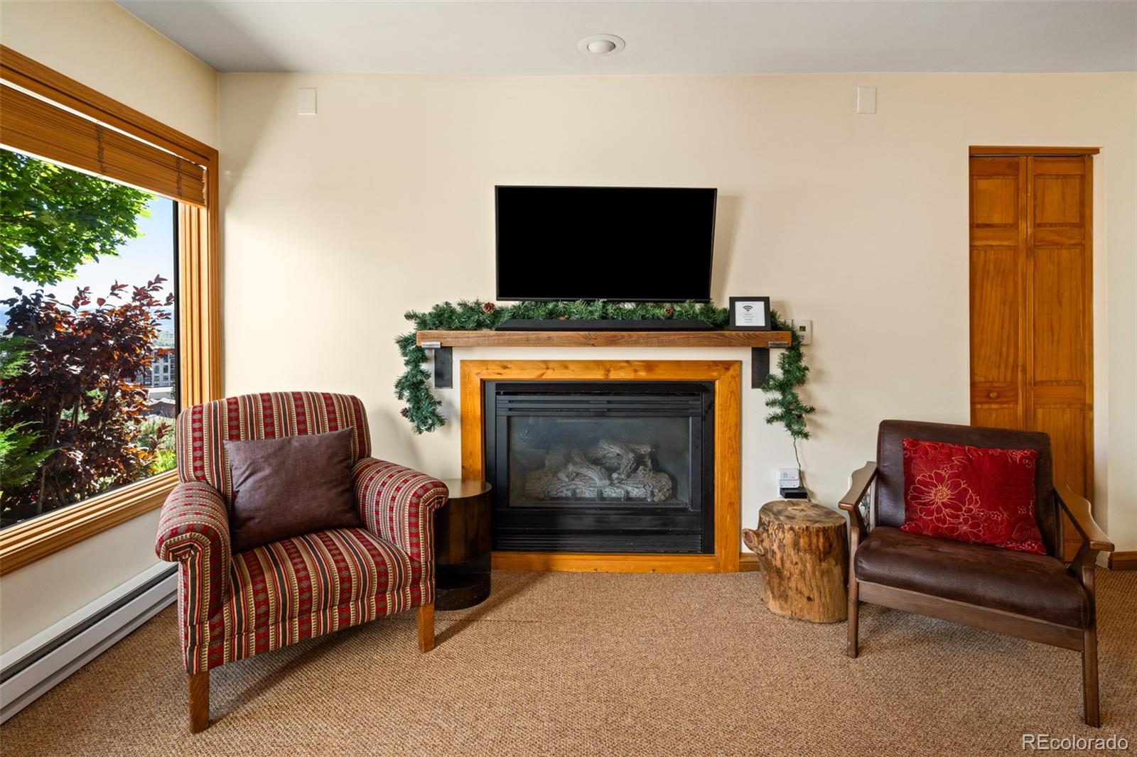 1800 Burgess Creek Road, Unit 205 Steamboat Springs, CO 80487 - Photo 8 of 28 a living room with furniture a flat screen tv and a fireplace
