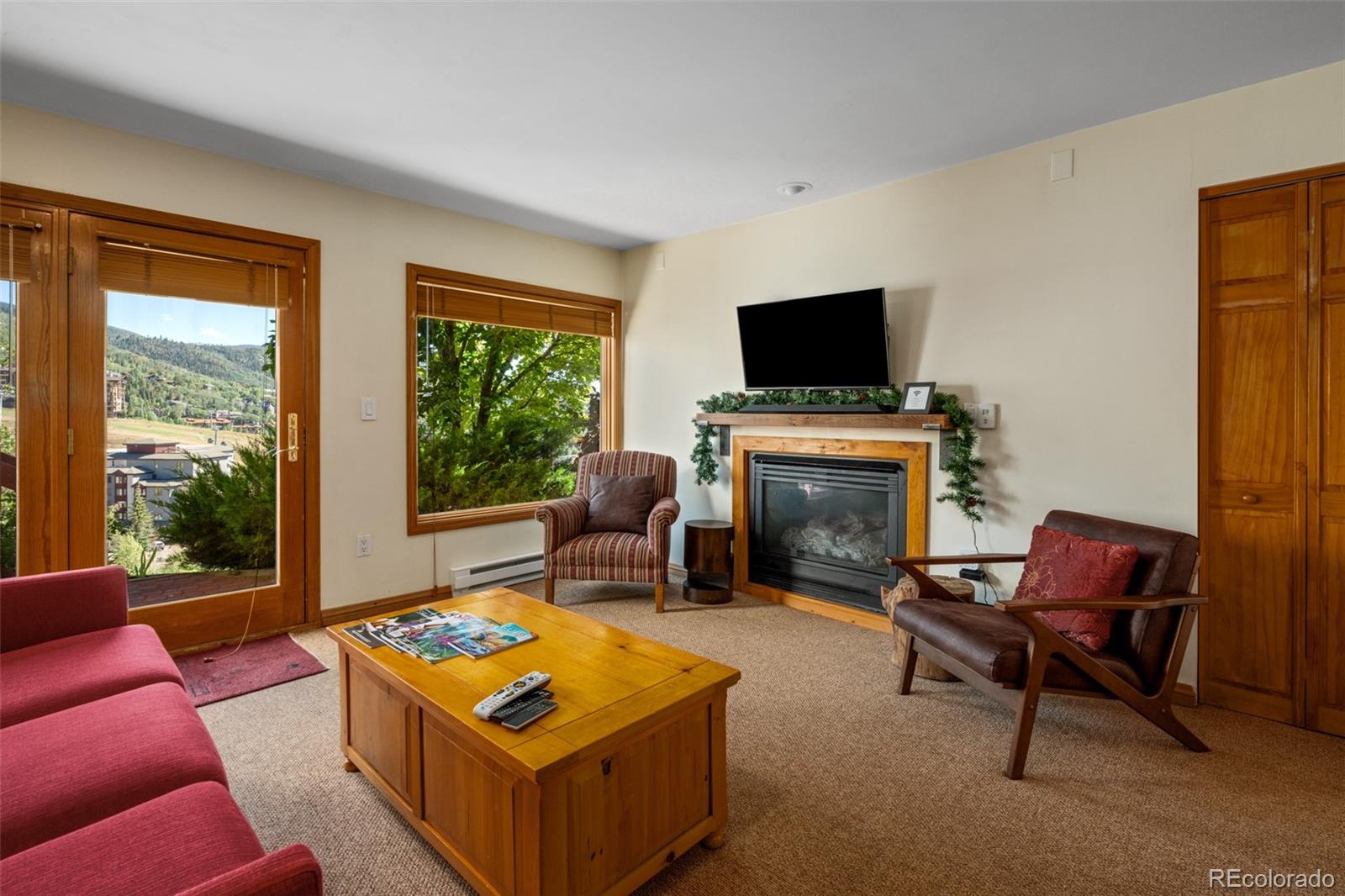 1800 Burgess Creek Road, Unit 205 Steamboat Springs, CO 80487 - Photo 9 of 28 a living room with furniture a flat screen tv and a fireplace