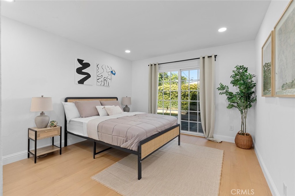 17131 Autumn Huntington Beach, CA 92647 - Photo 19 of 36 a spacious bedroom with a bed and a potted plant