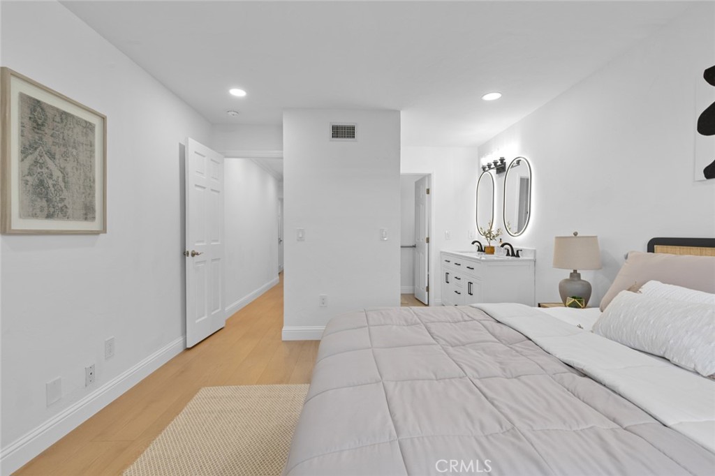 17131 Autumn Huntington Beach, CA 92647 - Photo 20 of 36 a spacious bedroom with a large bed and a chandelier