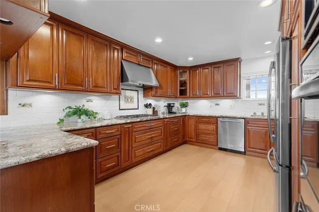 a kitchen with stainless steel appliances granite countertop wooden cabinets a stove a sink and a granite counter top
