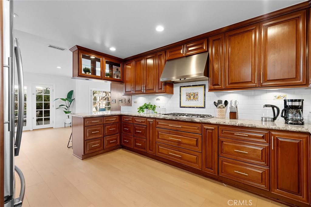 17131 Autumn Huntington Beach, CA 92647 - Photo 7 of 36 a kitchen with stainless steel appliances granite countertop wooden cabinets a stove top oven a sink and dishwasher