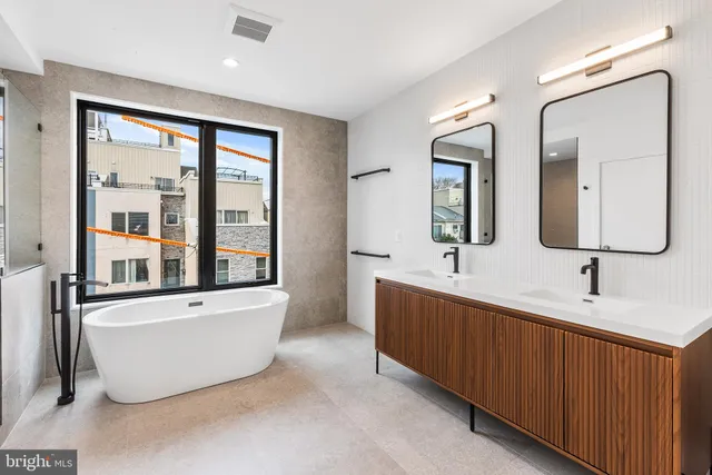 a white bath tub sitting in a bathroom next to a window