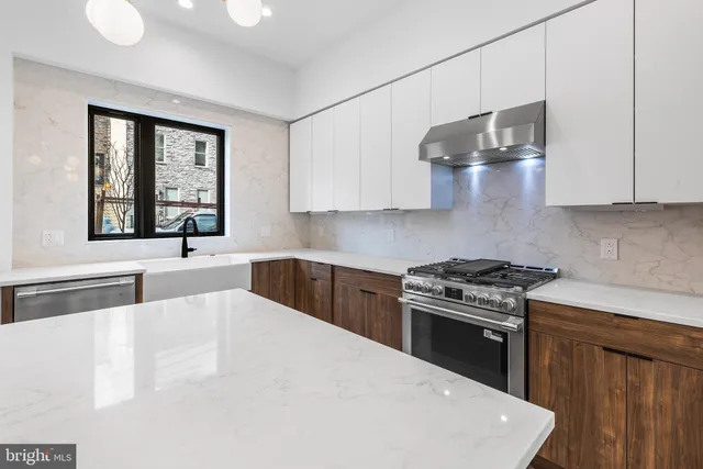 a kitchen with stainless steel appliances a sink stove and cabinets