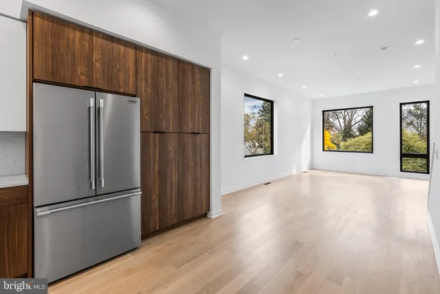 a view of a kitchen with wooden floors and stainless steel appliances