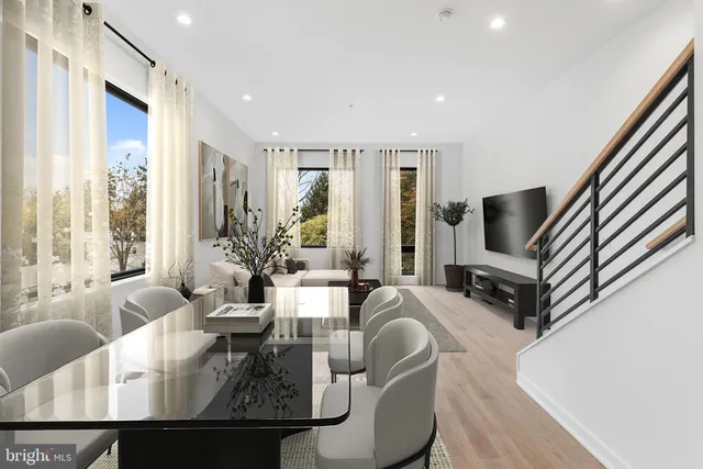 a living room with furniture a large window and a chandelier