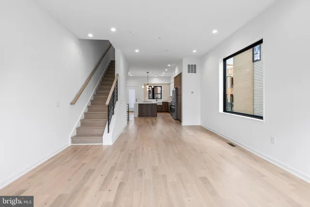 a view of a hallway with wooden floor and staircase