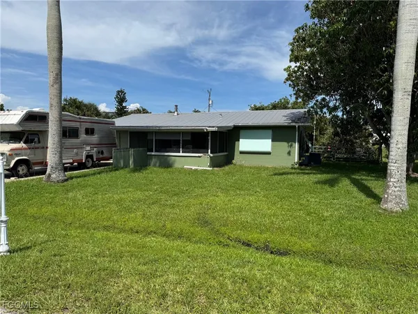 a view of a house with a yard and sitting area