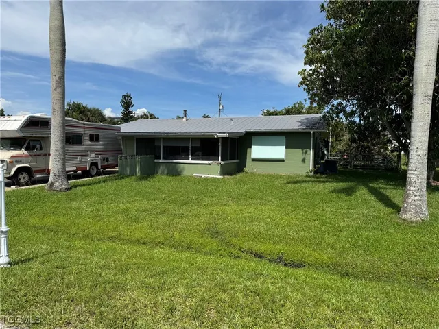 a view of a house with a yard and sitting area