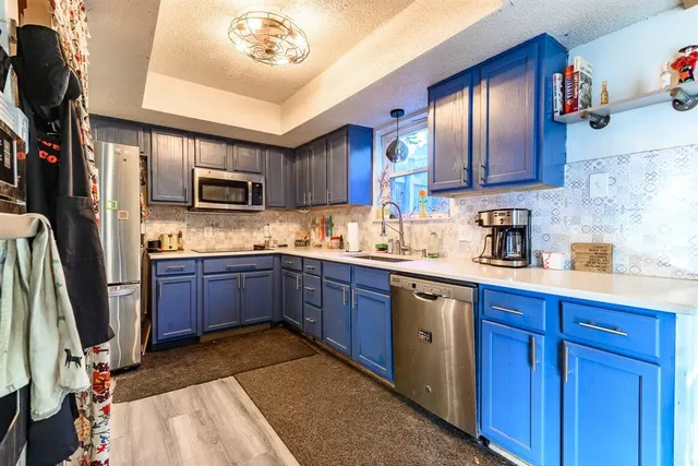 a kitchen with kitchen island granite countertop wooden cabinets a sink and stainless steel appliances