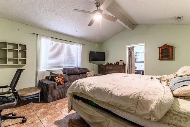 a bedroom with a bed a couch and a chandelier
