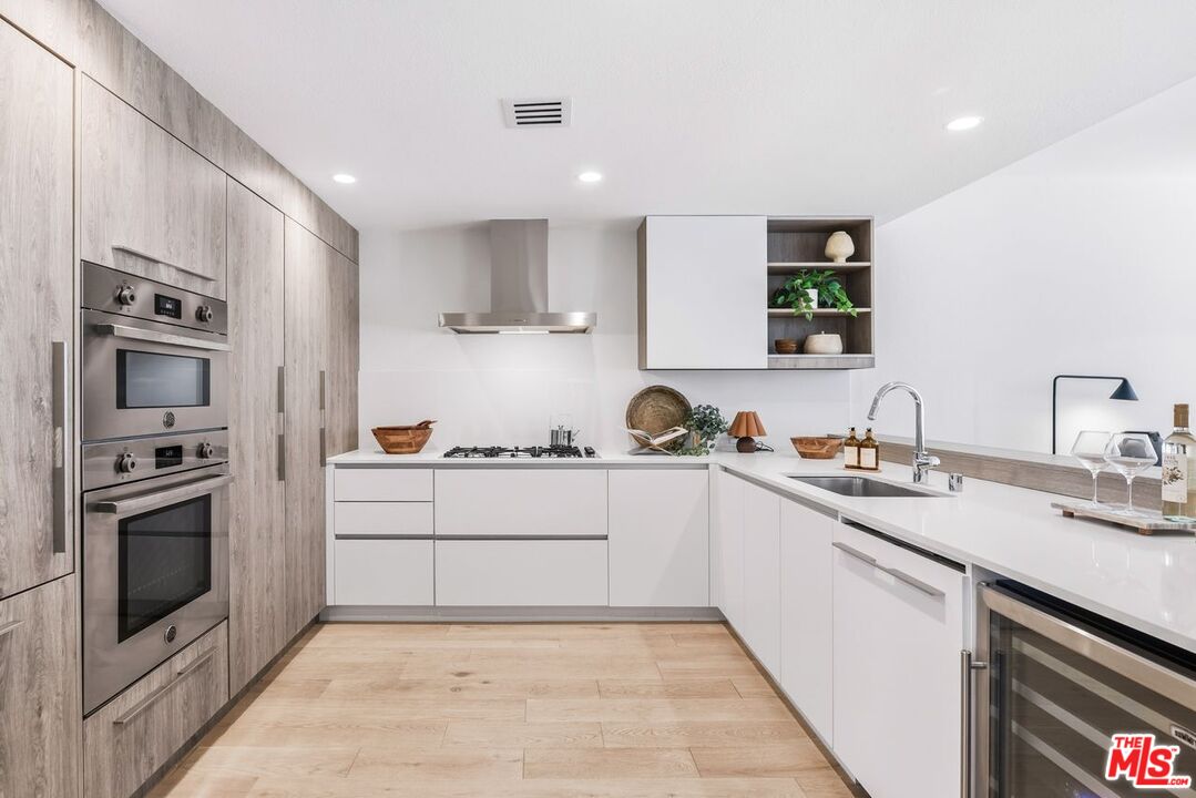 6487 Cavalleri Road, Unit 333 Malibu, CA 90265 - Photo 2 of 14 a kitchen with a sink white cabinets and stainless steel appliances