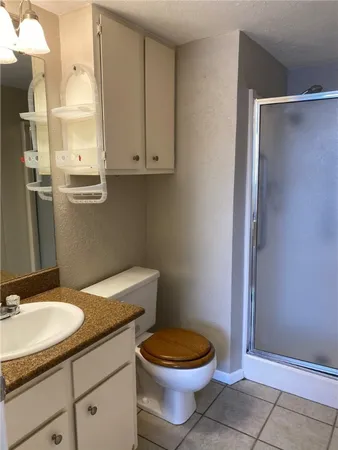 a bathroom with a granite countertop toilet a sink and a mirror