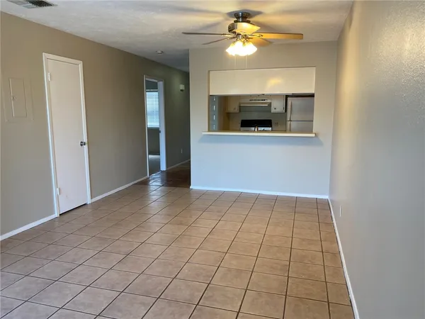 a view of an empty room and window chandelier fan