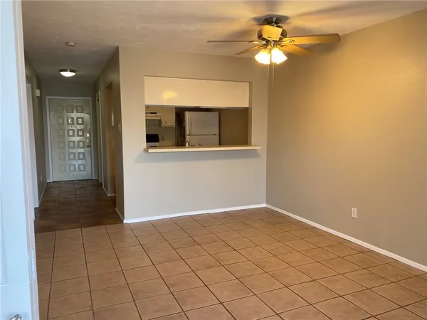 a view of an empty room with a chandelier fan