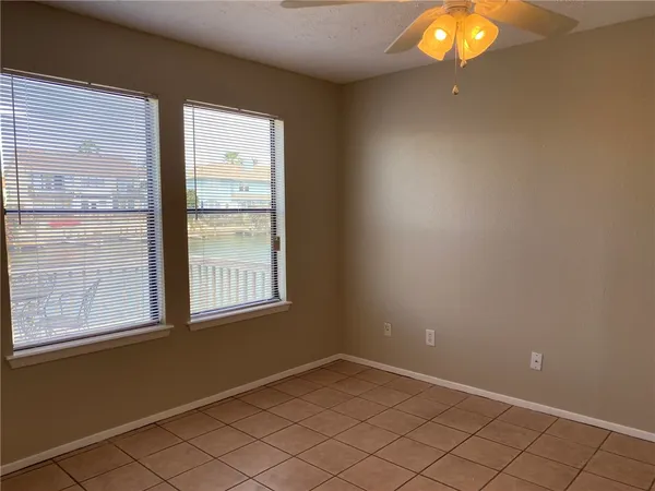 a view of an empty room with a chandelier fan