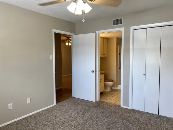 an empty room and a bathroom with a toilet