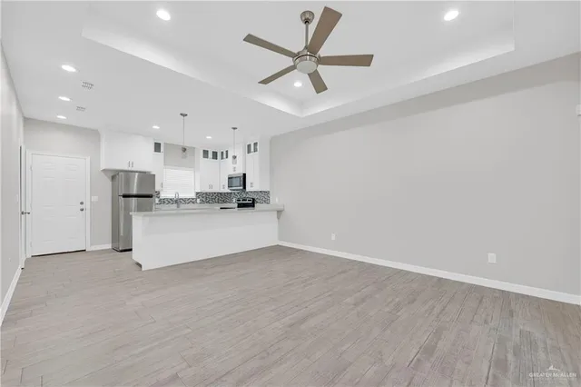 a view of a kitchen with a sink and wooden floor