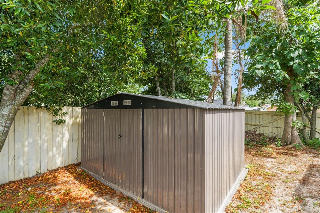 12292 Ronald Street Spring Hill, FL 34609 - Photo 17 of 18 a backyard of a house with large trees and wooden fence