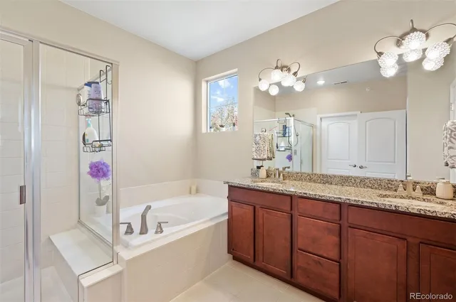 a bathroom with a granite countertop bathtub a sink and a mirror