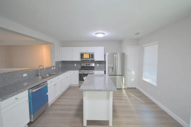 a large kitchen with stainless steel appliances lots of counter space and a sink