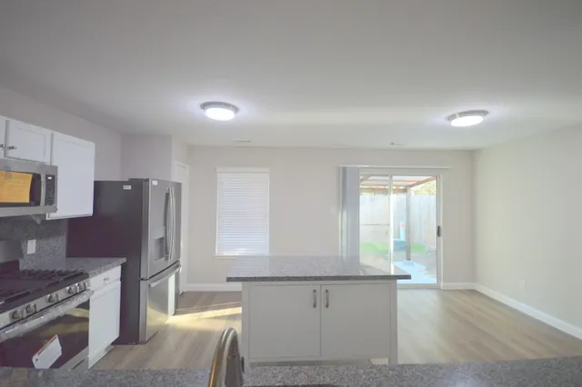 a kitchen with stainless steel appliances granite countertop a refrigerator and a stove top oven