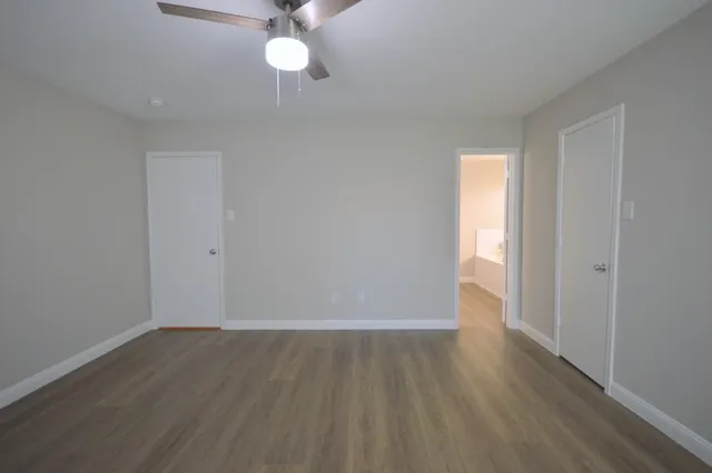 a view of a room with wooden floor and a ceiling fan