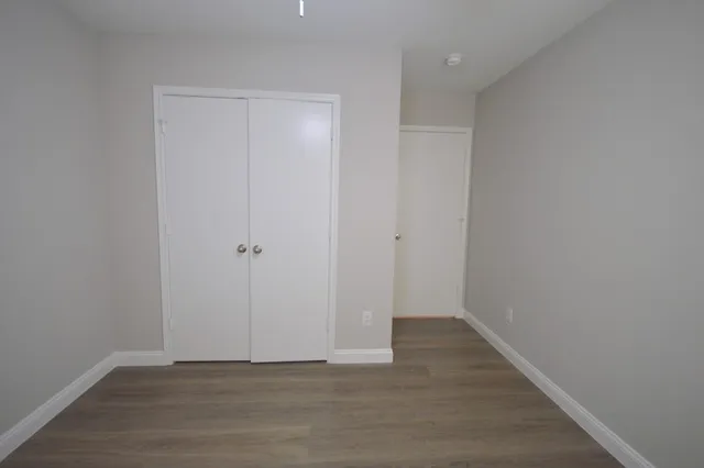 a view of an empty room with wooden floor