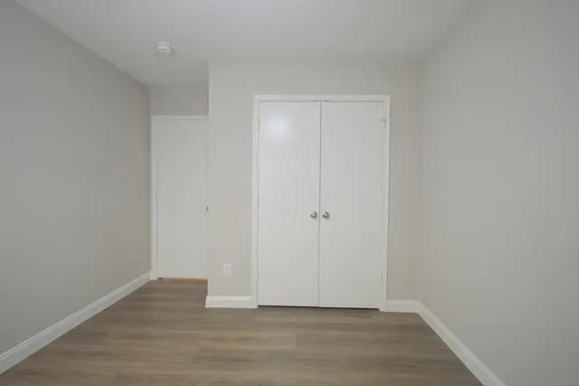 a view of an empty room with wooden floor