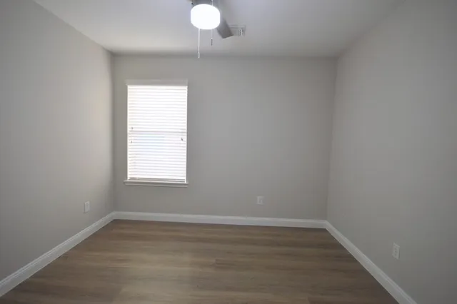 a view of a room with wooden floor and window