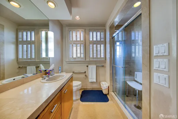 a bathroom with a sink a toilet and shower