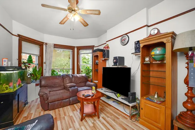 a living room with furniture a flat screen tv and a floor to ceiling window