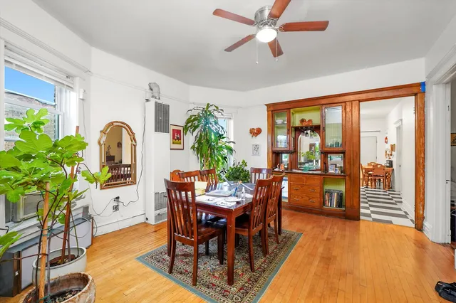 a dining room with furniture potted plants and wooden floor