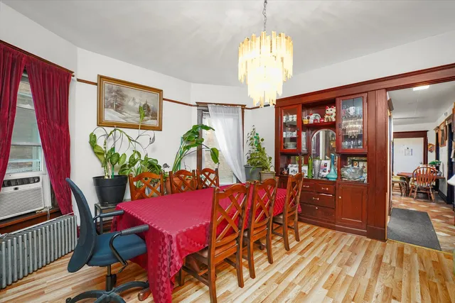 a view of a dining room with furniture a chandelier and wooden floor