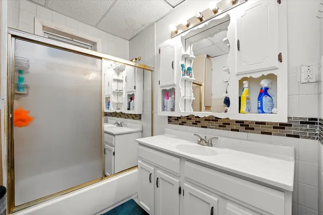 a bathroom with a sink vanity granite shower and a mirror