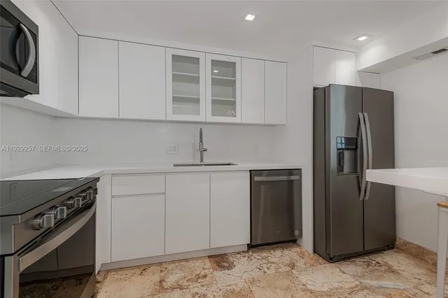 a kitchen with stainless steel appliances granite countertop a refrigerator and a stove