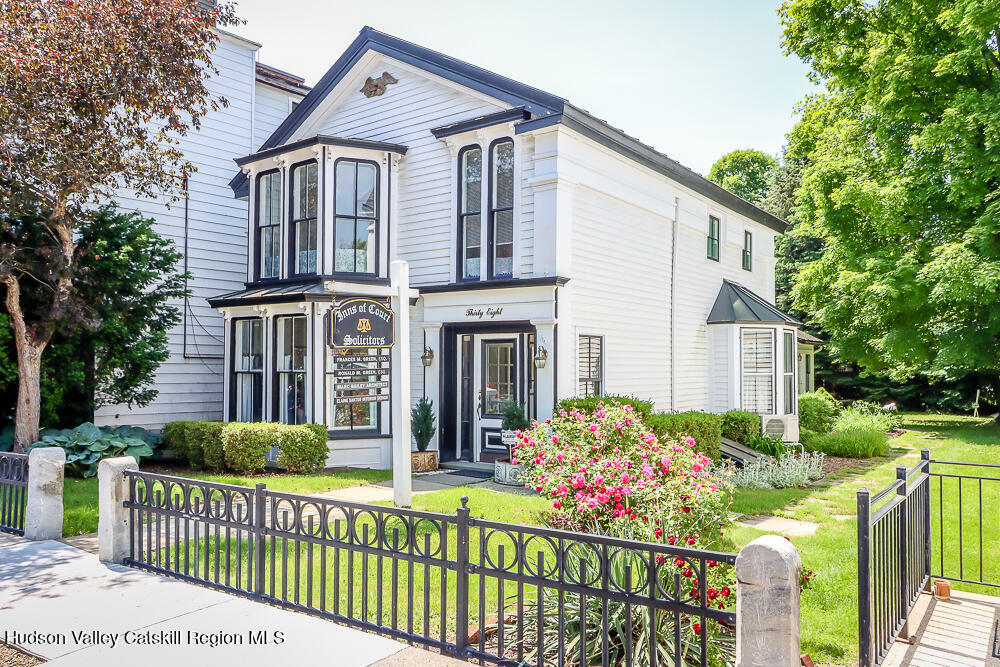 38 Main Street Chatham, NY 12037 - Photo 1 of 28 a front view of house and yard with beautiful flowers and green space