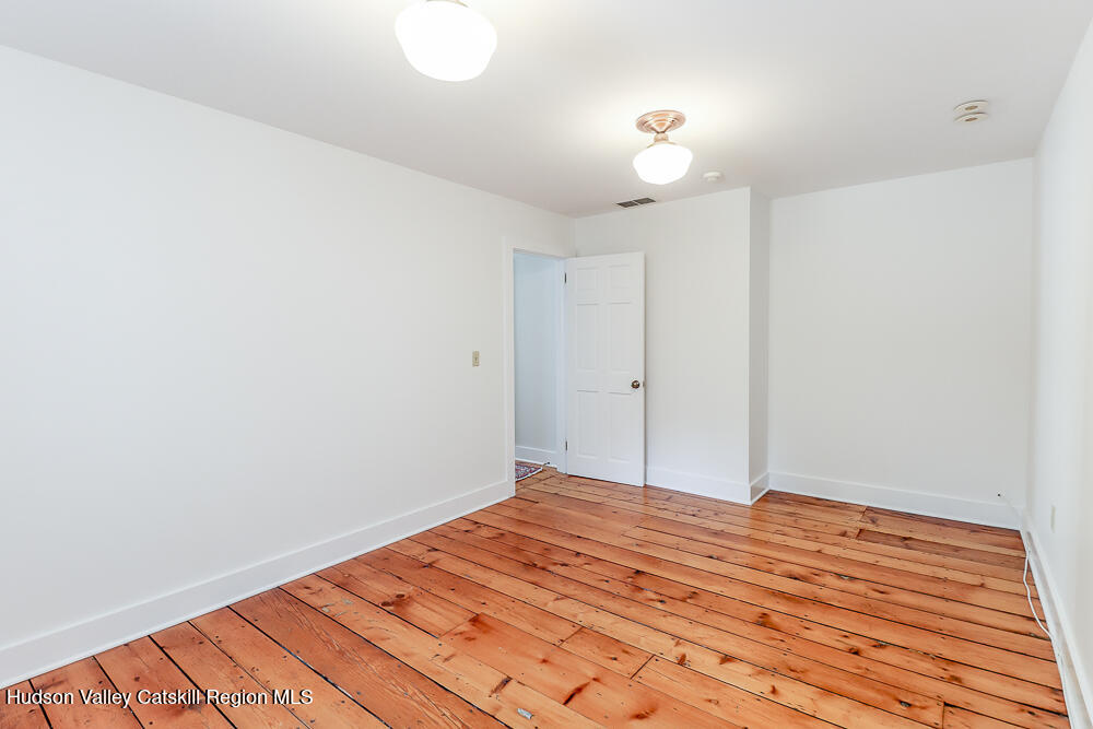 38 Main Street Chatham, NY 12037 - Photo 23 of 28 a view of a room with wooden floor and a ceiling fan