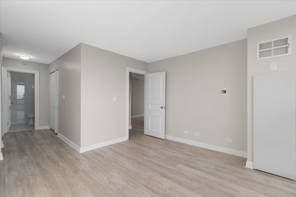 10 East Ontario Street, Unit 480102 Chicago, IL 60611 - Photo 27 of 41 a view of an empty room with wooden floor