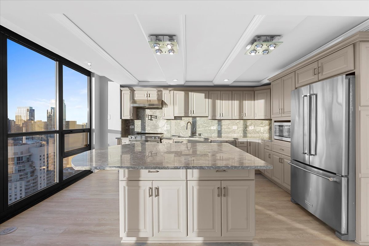 10 East Ontario Street, Unit 480102 Chicago, IL 60611 - Photo 3 of 41 a kitchen with stainless steel appliances granite countertop a refrigerator a stove and a sink with large countertops