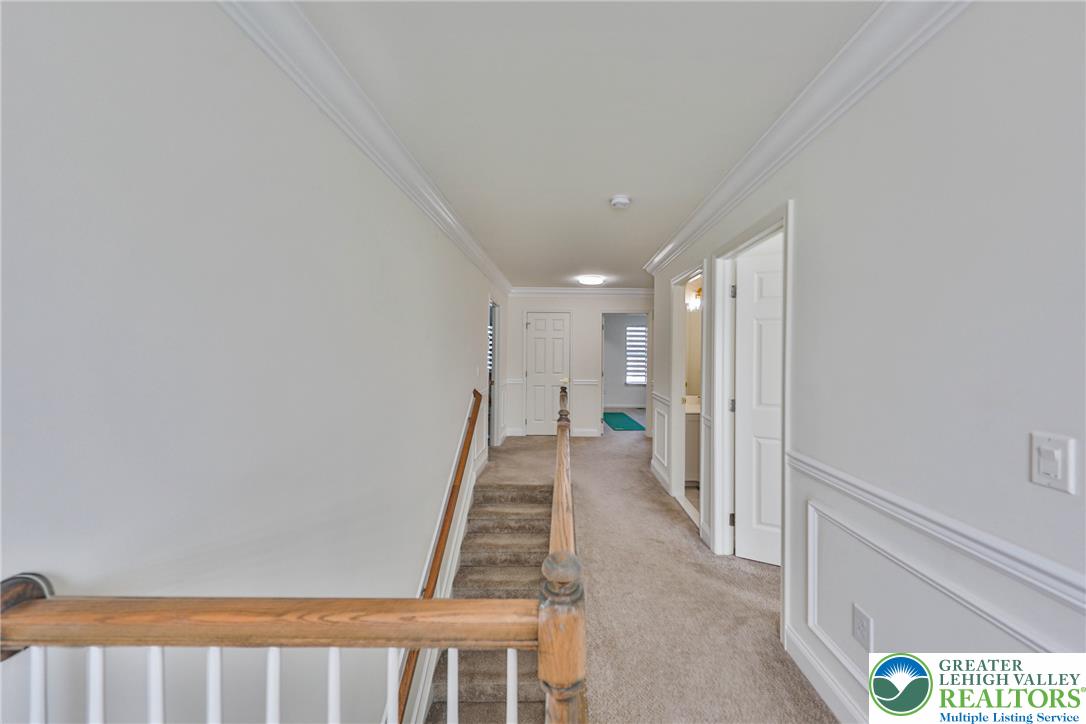 1105 Meco Road Easton, PA 18040 - Photo 72 of 100 Crisp white wainscoting and classic crown molding line this carpeted upper level hallway.