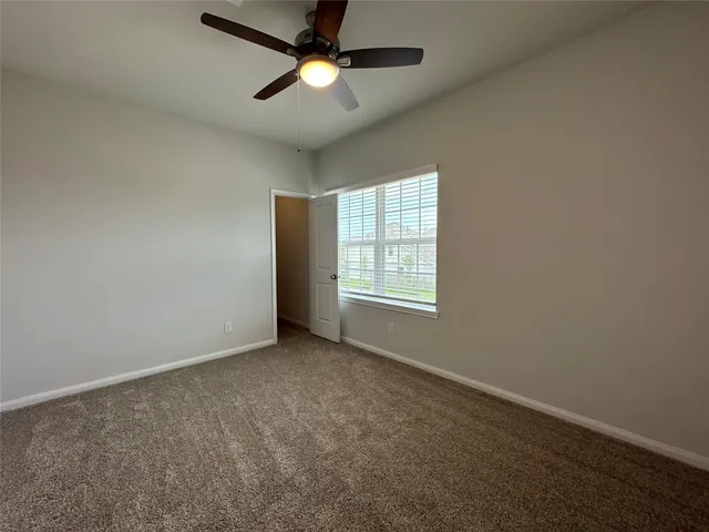 an empty room with a window and a fan