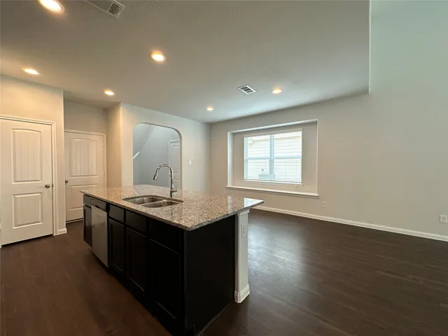 an open kitchen with a sink cabinets and wooden floor