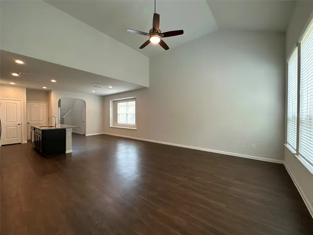 a view of a livingroom with a kitchen stove wooden floor and a window