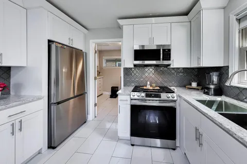 a kitchen with cabinets stainless steel appliances and a sink