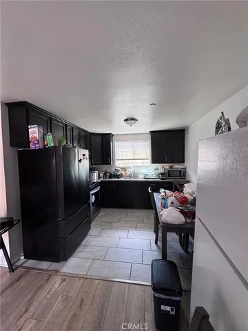 a kitchen with stainless steel appliances kitchen island granite countertop a refrigerator and a stove top oven