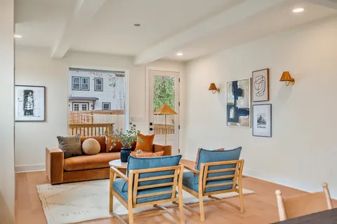 a living room with furniture a rug and a window