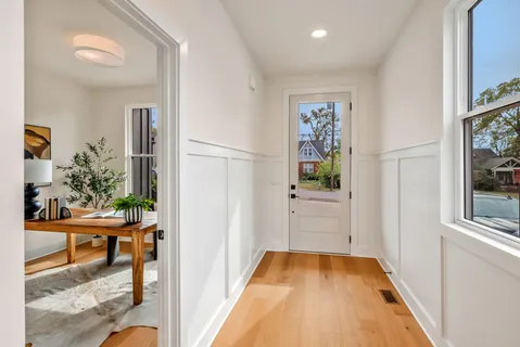 a view of a hallway to a livingroom with furniture and wooden floor